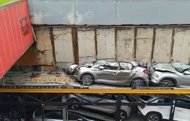 Carro fica destruído após cair de caminhão-cegonha que entalou em